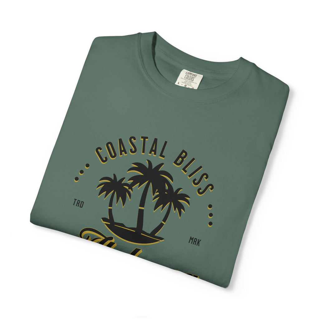 Folded green t-shirt with 'Coastal Bliss' text and palm tree design on a white background