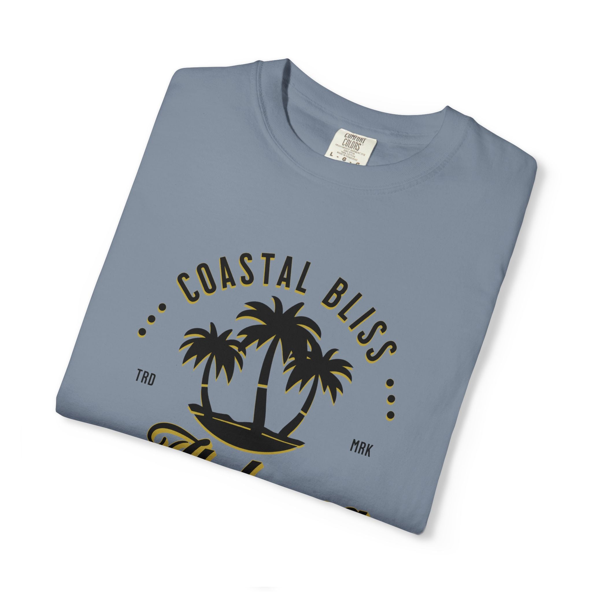 Folded blue t-shirt with 'Coastal Bliss' text and palm tree design on a white background