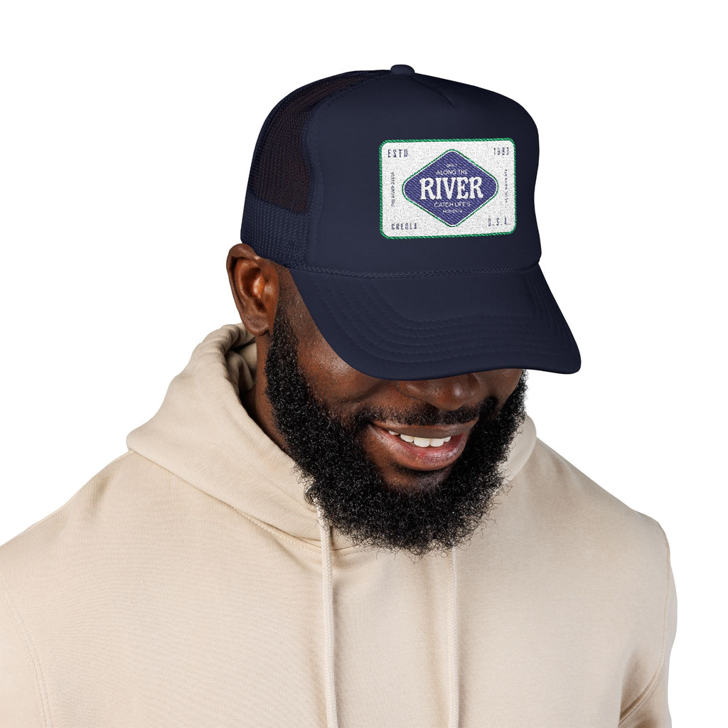 Man wearing a navy blue cap with a logo of the River Delta based in Creola Alabama 