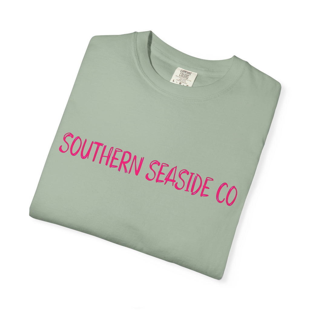 Folded light green t-shirt with 'Southern Seaside Co' in pink text on a white background