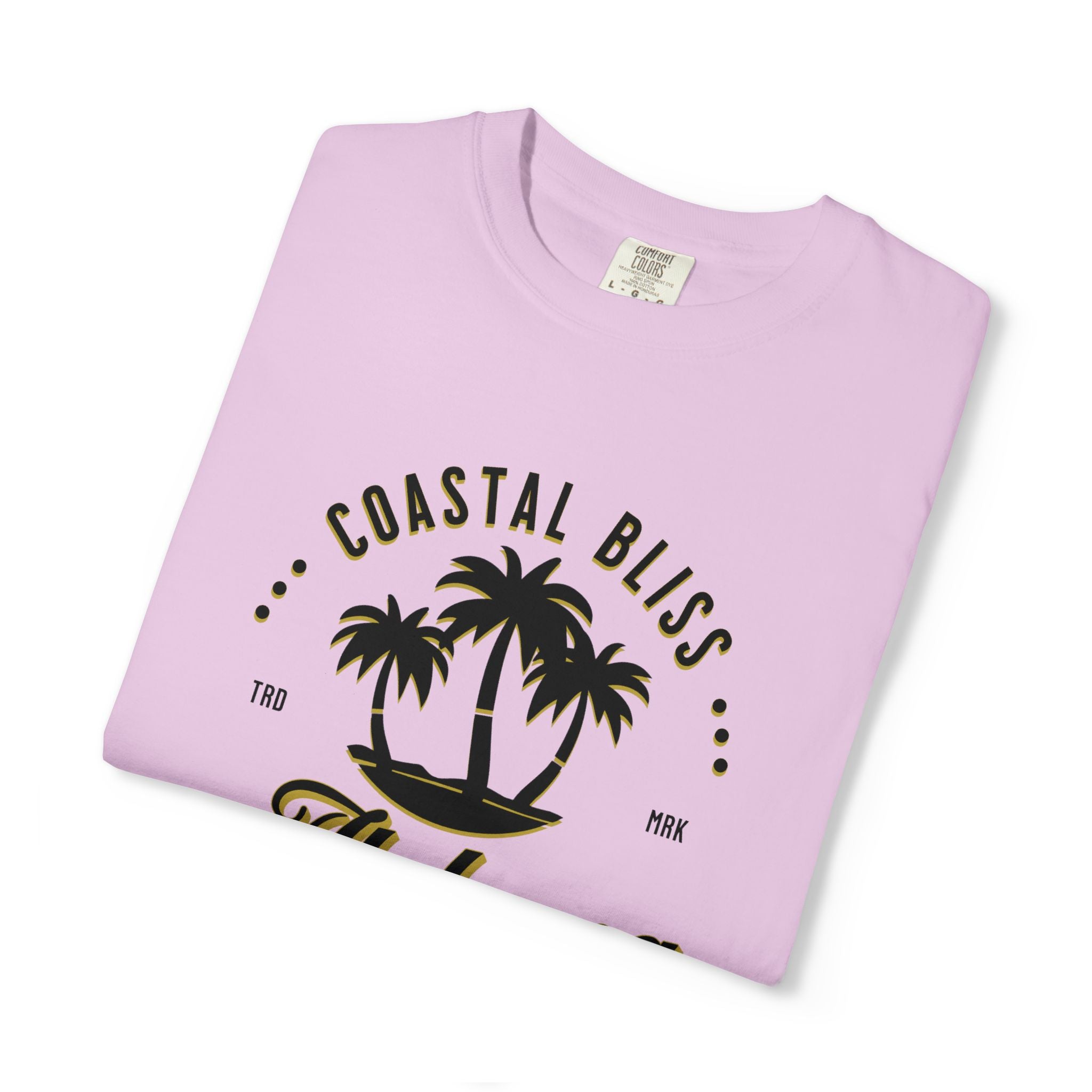 Folded pink t-shirt with 'Coastal Bliss' text and palm tree design on a white background