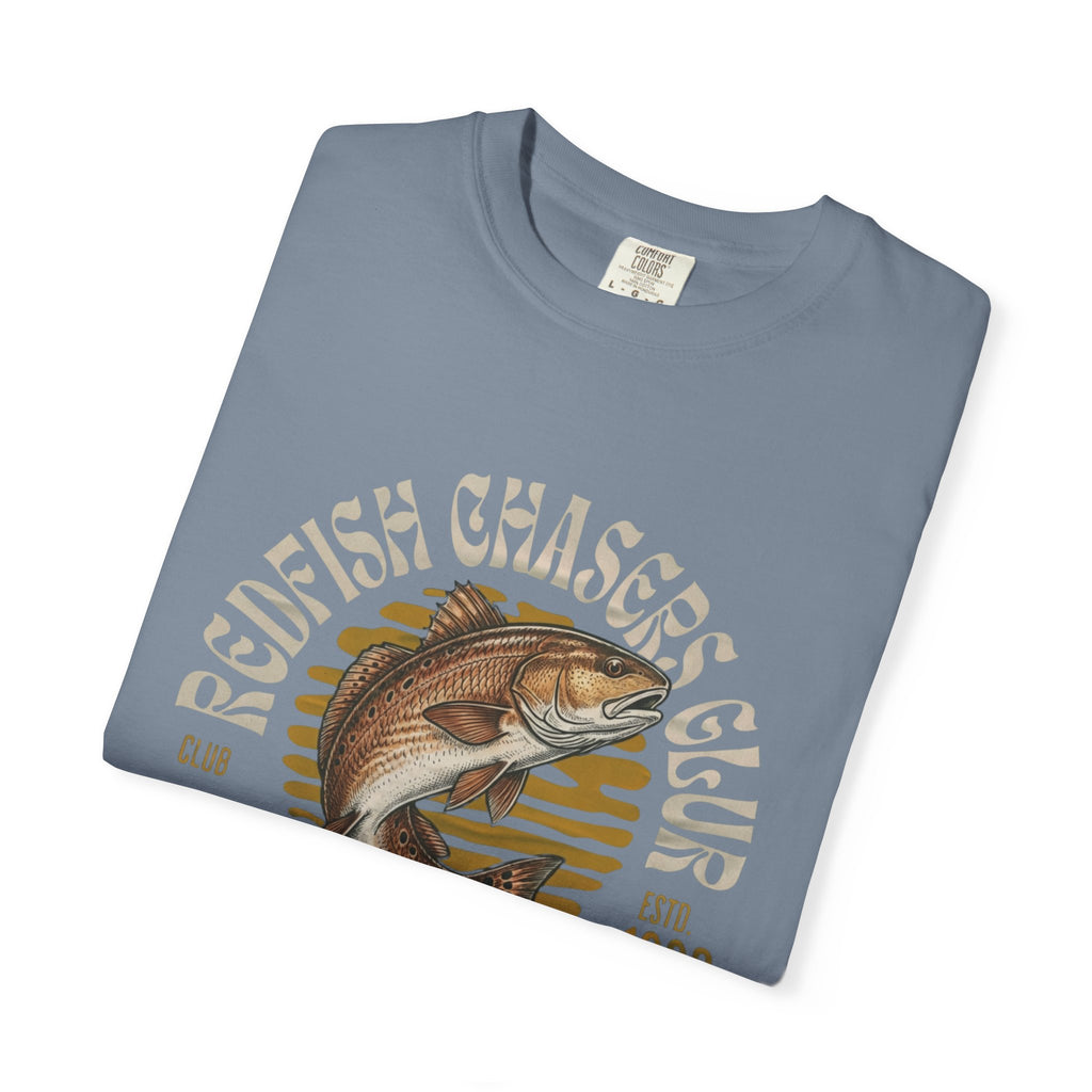 Folded blue t-shirt with redfish graphic and 'Redfish Chasers Club' text on a white background