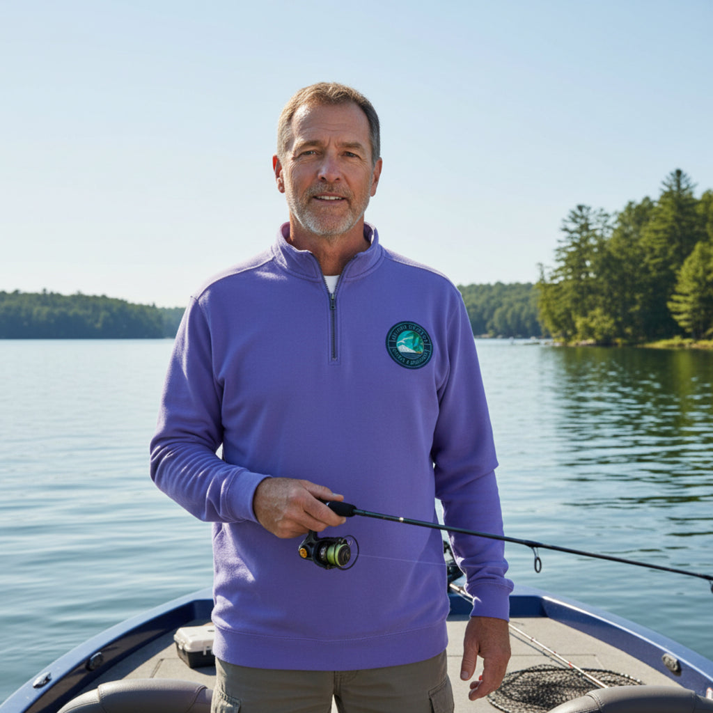 Comfort Colors Quarter Zip Sweatshirt. Man in a purple pullover with a Southern Seaside Company logo on a boat by a lake