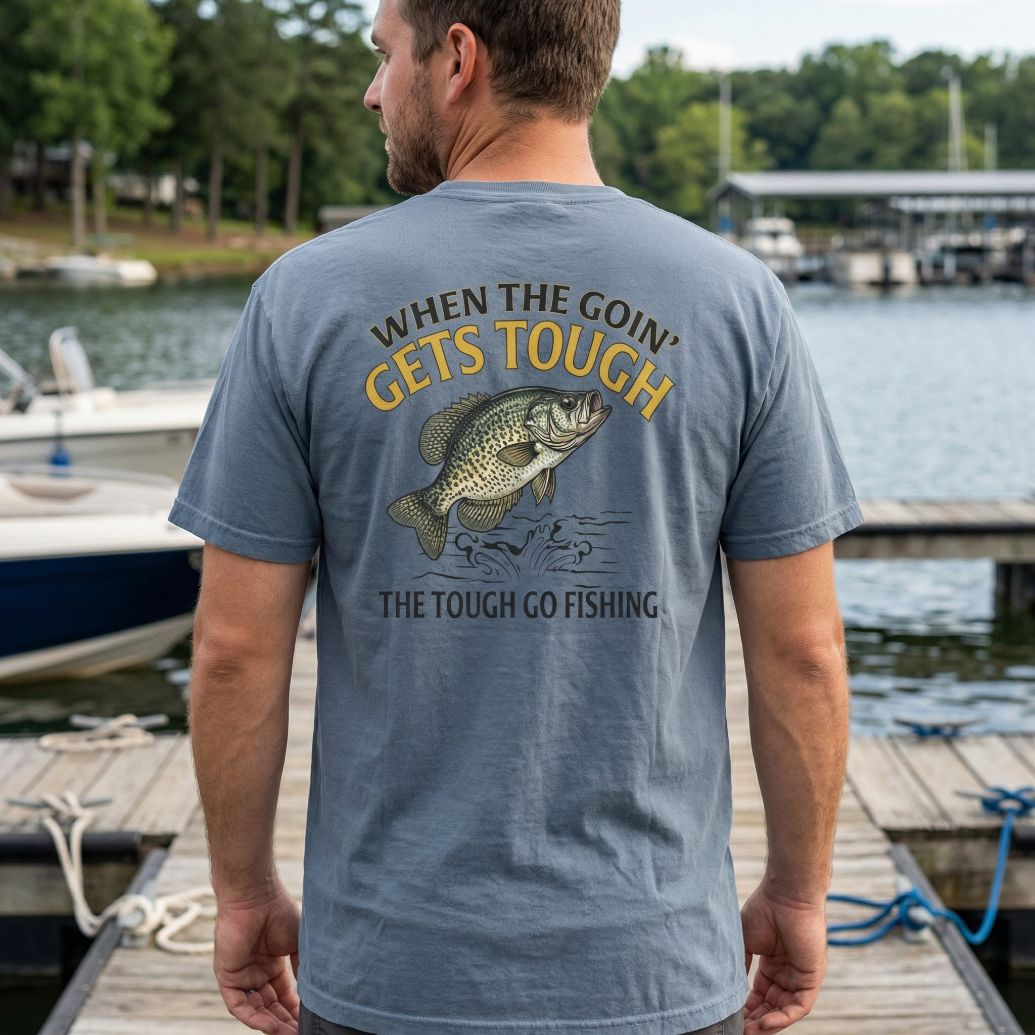 Man wearing a crappie fishing-themed t-shirt with a lake and dock in the background