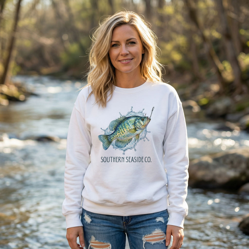 Crappie Fishing Sweatshirt that is white with a woman wearing it in an outdoor fishing scene.
