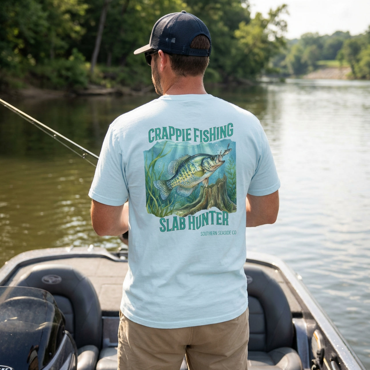 Man on a boat wearing a light blue t-shirt with crappie fishing design.