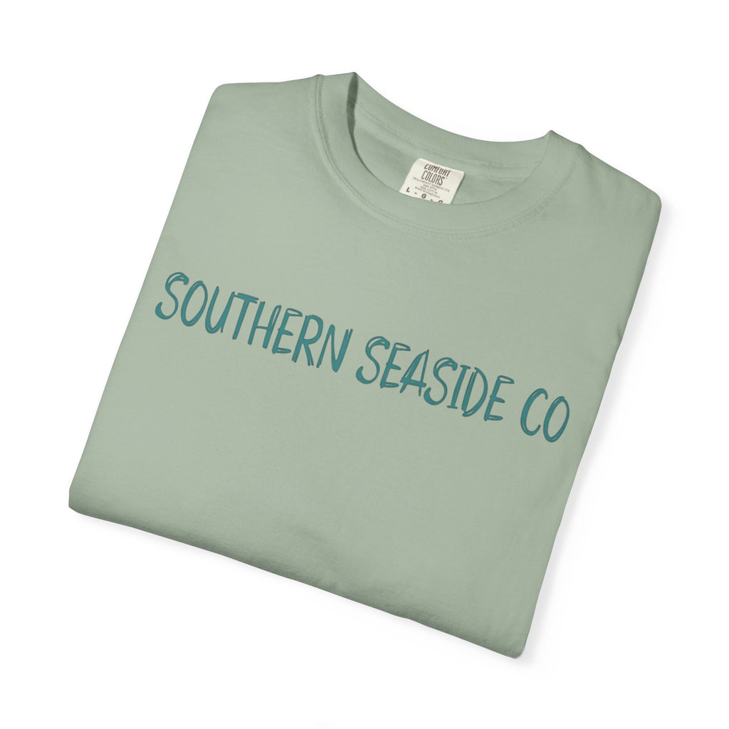 Folded green t-shirt with 'Southern Seaside Co' text on a white background